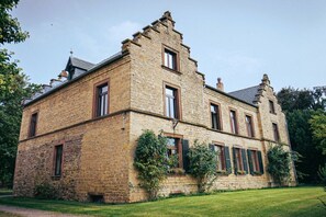 A stone building with multiple windows and a symmetrical facade. - Vlatten Manor House - Under the Roof (Heimbach)