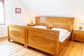 A wooden bed with a headboard, two bedside tables, and a nightstand. - Vlatten Manor House - Under the Roof (Heimbach)
