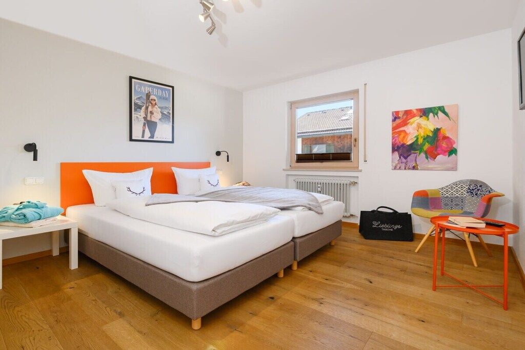 Habitación de hotel moderna con cama, mesita de noche, una silla y ventana.