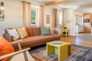 Un salon moderne avec un canapé, une table basse et une vue sur la cuisine.