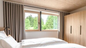 Une chambre à coucher avec un lit, une armoire et une fenêtre avec des rideaux.