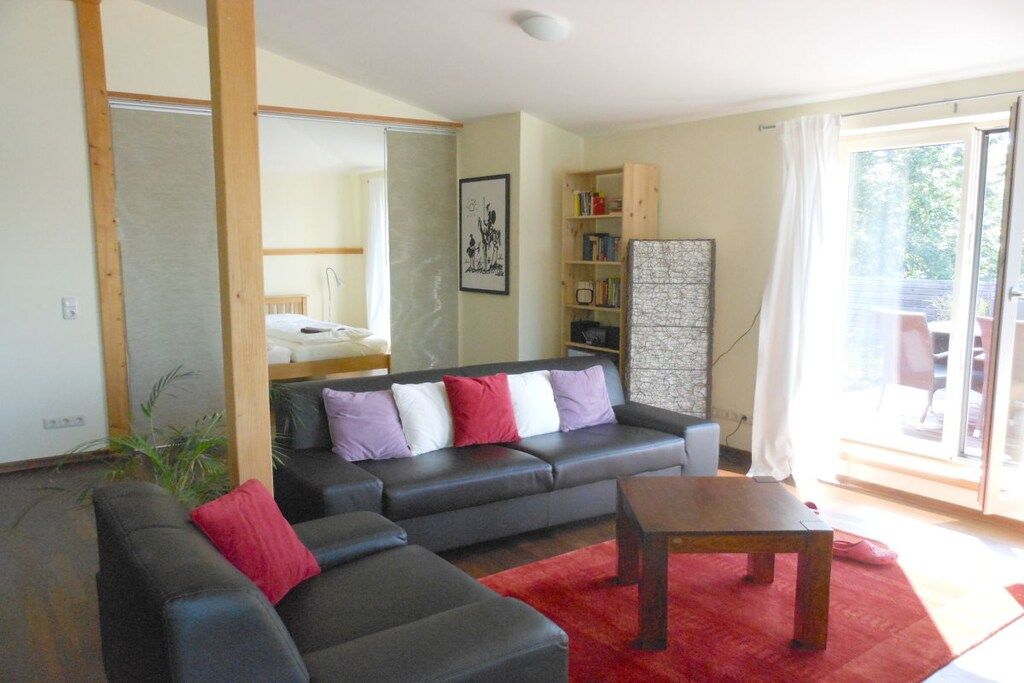 Una sala de estar con un sofá, una mesa de centro y una estantería.
