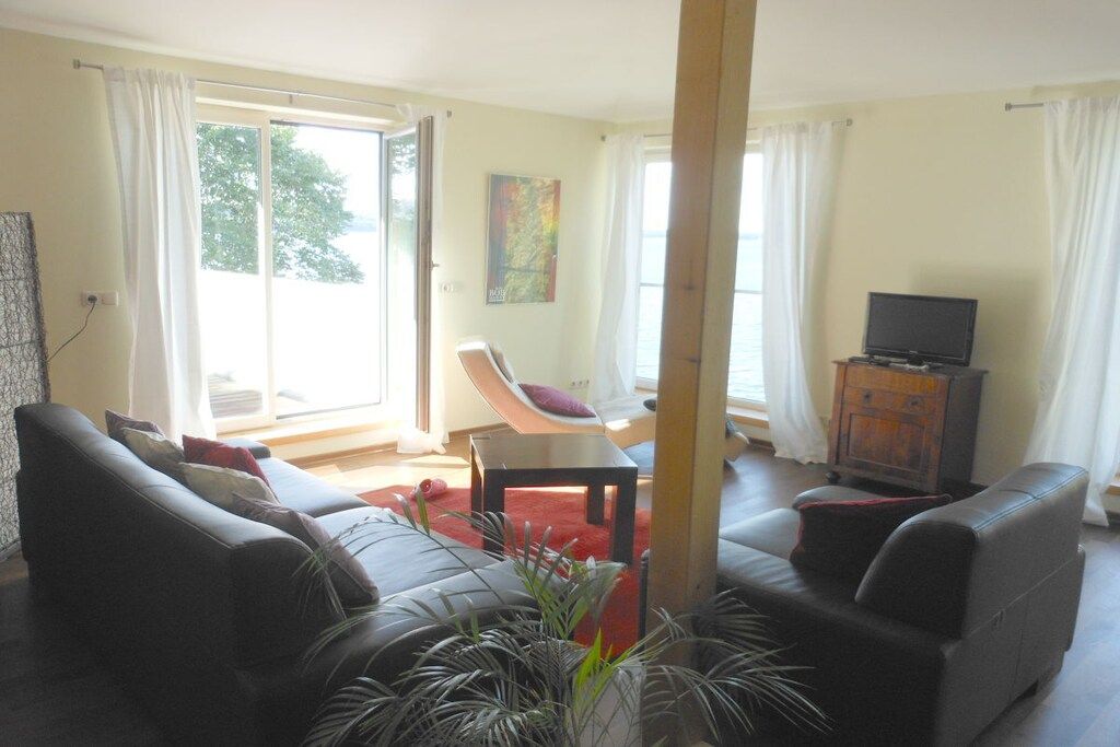 Una sala de estar con sofá, sillón, televisor y chimenea.