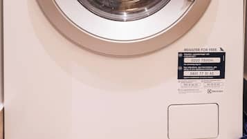 A front view of a white Electrolux washing machine with a control panel, a dial, and a label for Woolmark Wool Hand Wash Safe certification.