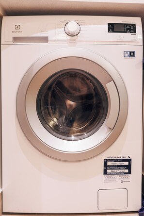 Een voorweergave van een witte Electrolux wasmachine met bedieningspaneel, een draaiknop en een label voor Woolmark Wol Handwas Veilig certificering.