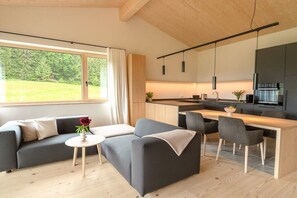 A modern living space with a sofa, coffee table, and dining area. - Holiday apartment Himmel (Bolsterlang)