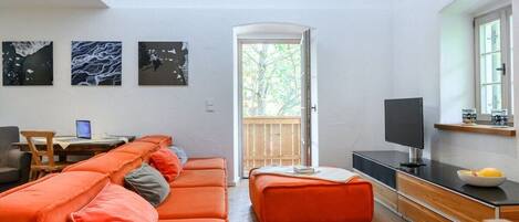 Una sala de estar moderna con un sofá, un televisor y obras de arte en la pared.