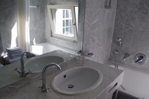 Een badkamer met een dubbele wastafel, een badkuip en een douche.