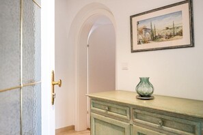 A hallway with a door, a framed painting, and a green vase on a dresser. - Holiday apartment with 2 bedrooms (Garmisch-Partenkirchen)