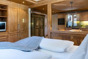 Ein Schlafzimmer mit einem Bett, einem Holzschrank und einem Fernseher.