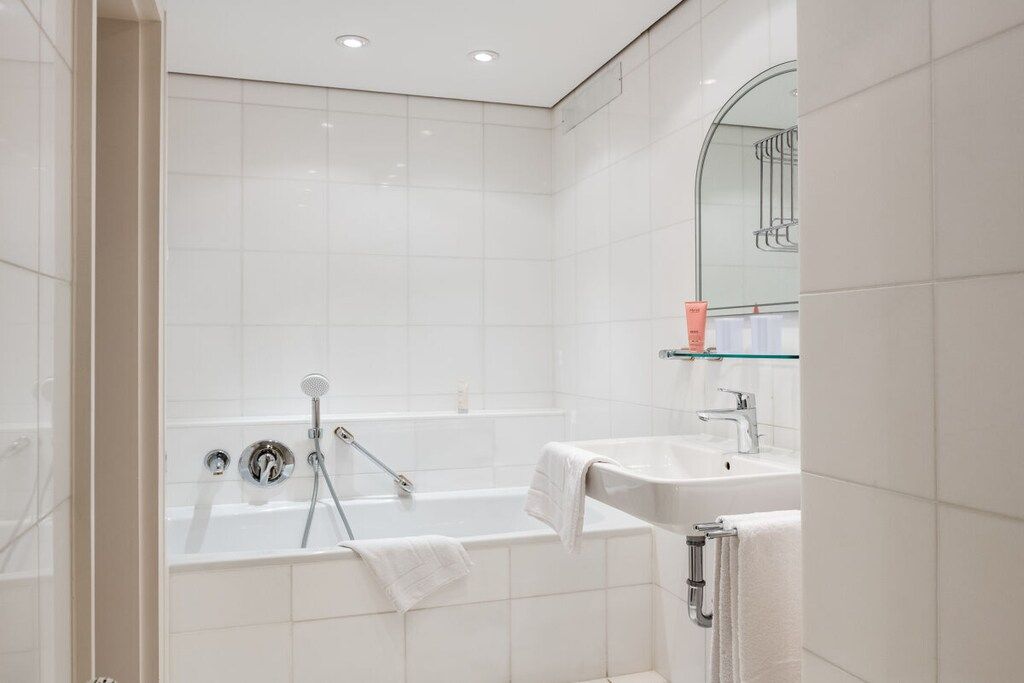 Een moderne badkamer met een badkuip, een wastafel en een douchecabine van glas.