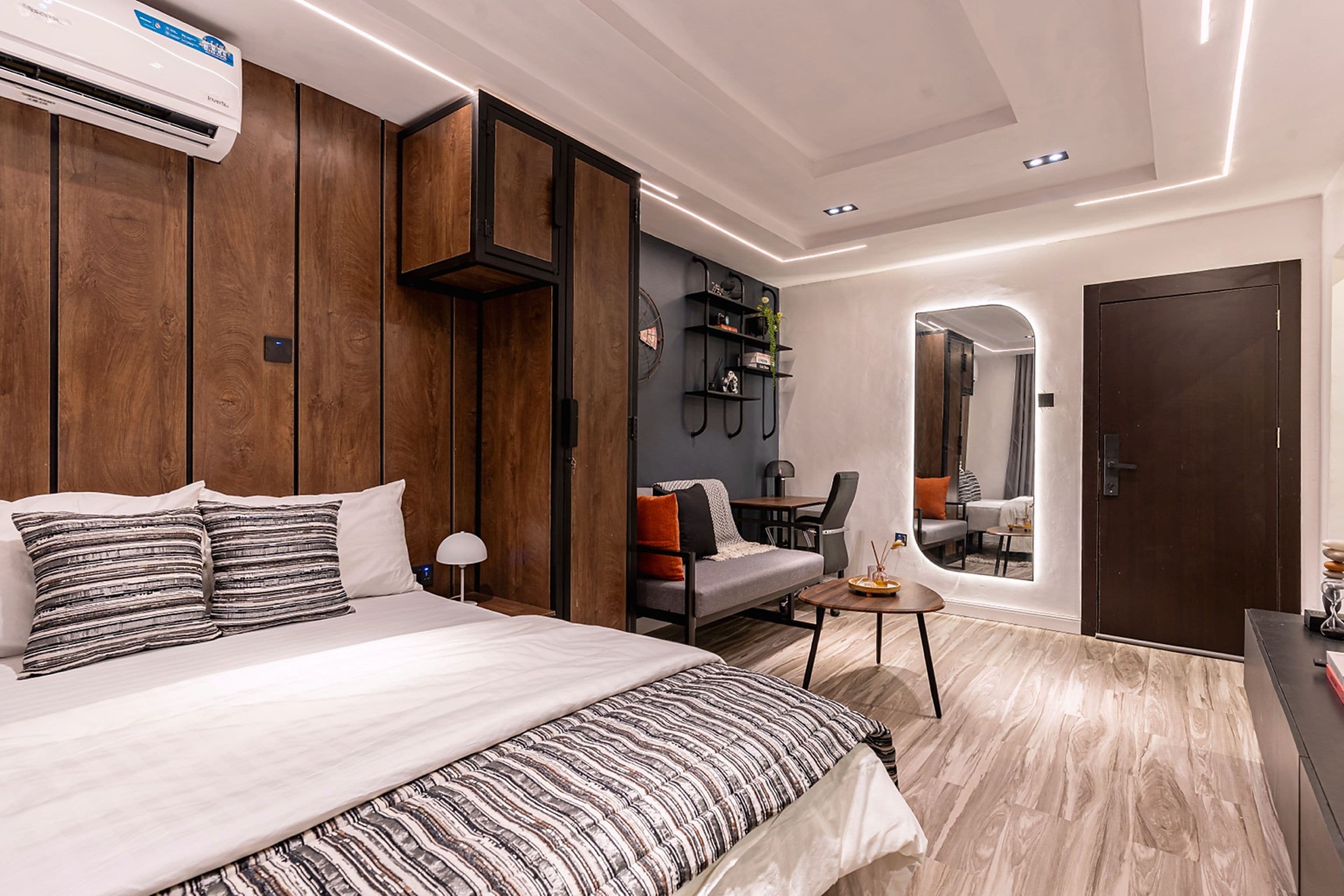 Ein modernes Schlafzimmer mit einem großen Bett, einem Schreibtisch und einer Sitzecke.