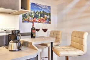 A compact kitchen with a coffee maker, wine glasses, and a bottle on the counter. - Alpklang Apartment #3 (Garmisch-Partenkirchen)