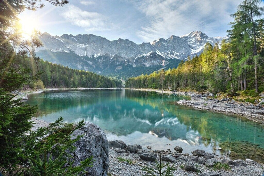 Un lac de montagne entouré de forêts et de terrains rocheux.