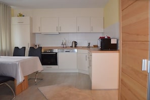 A compact kitchen with white cabinets, a stove, a sink, and a small refrigerator. - Holiday home in Hülben with swimming pool (Hülben)