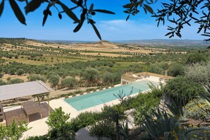 Ein Pool mit Blick auf Olivenhaine und ferne Hügel.