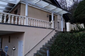 A two-story house with a balcony, a staircase, and a hedge. - Dream view of the Rursee (Simmerath-Woffelsbach)