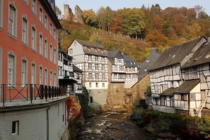 A narrow street with traditional half-timbered houses on one side and a red building on the other. - Dream view of the Rursee (Simmerath-Woffelsbach)