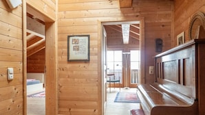 A wooden interior with a bench, a framed notice, and a door leading to another room. - Holiday home with 3 bedrooms (Weitnau-Hellengerst)
