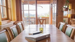 A wooden dining table with chairs, a notebook, and a pen. - Holiday home with 3 bedrooms (Weitnau-Hellengerst)