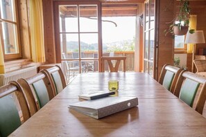 Una mesa de madera con sillas, un cuaderno y un bolígrafo.