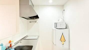 A compact kitchen with a sink, a stove, and a refrigerator.