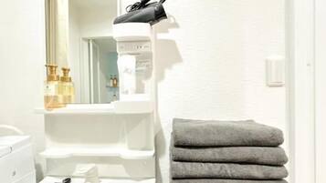 A bathroom with a sink, mirror, towel rack, and a white wall.
