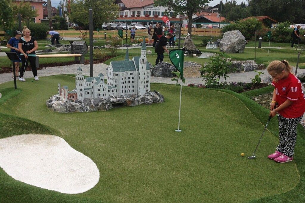 En miniatyrgolfbana med ett hål som är utformat som ett slott, en puttinggreen och en sandfälla.