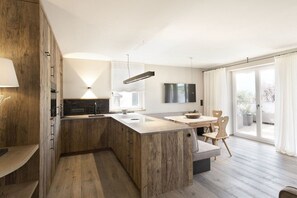 Une cuisine moderne avec des meubles en bois, un îlot central et un coin repas comprenant une table et des chaises.
