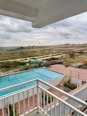 A swimming pool with a view of a hilly landscape. - Charming apartment in Pridelands with access to fitness room (Pridelands)