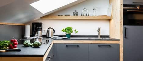 Una cocina moderna con tragaluz, armarios de madera y horno empotrado.