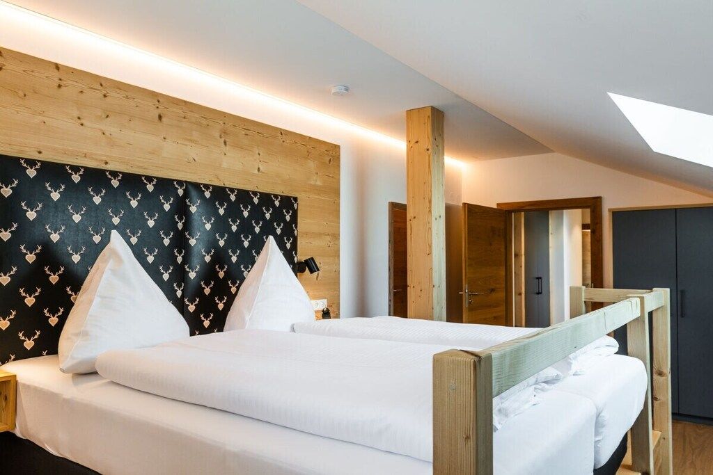 Una stanza con un letto, una testiera in legno e un lucernario.