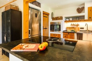 Eine moderne Küche mit einem Edelstahl-Kühlschrank, Backofen und einer Glaskochplatte.