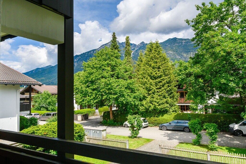 Zona residencial com vista para montanhas, um estacionamento e um edifício com telhado em cerâmica.