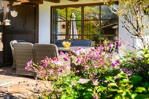 An outdoor seating area with wicker furniture and a table with fruit. - Holiday apartment with 1 bedroom (Farchant)