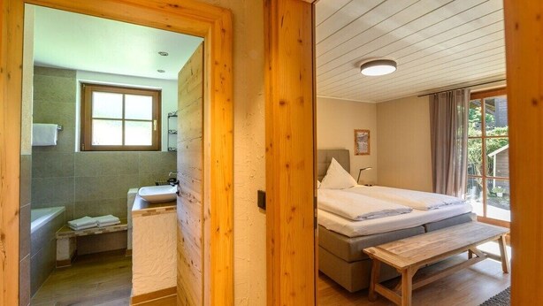 Un interior de madera con un baño y un dormitorio.