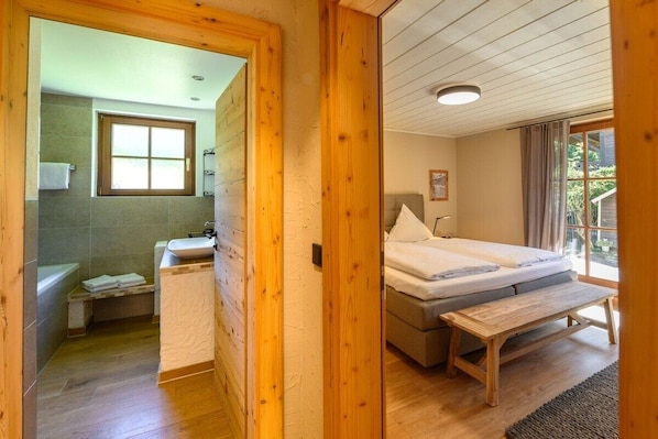Een houten interieur met een badkamer en een slaapkamer.