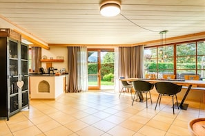 A modern kitchen with a dining area, large windows, and a view of greenery. - Holiday apartment with 1 bedroom (Farchant)