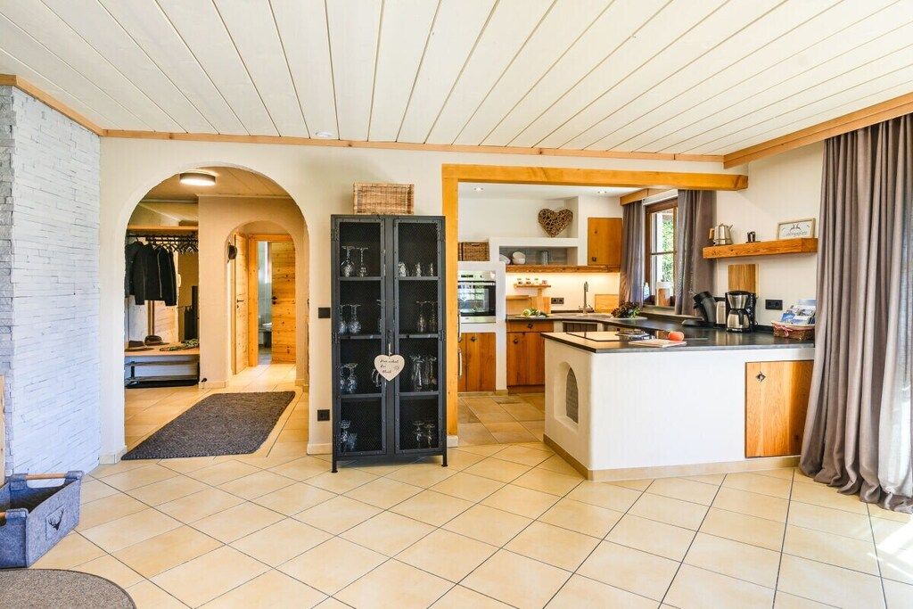 Eine moderne Küche mit einer zentralen Kochinsel, Holzschränken und einem eingebauten Backofen.