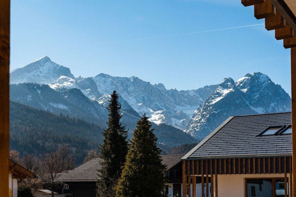 A mountain view with a wooden building in the foreground.