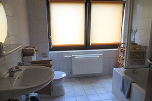 A bathroom with a toilet, sink, and bathtub. - Holiday apartment with 3 bedrooms (Damscheid)