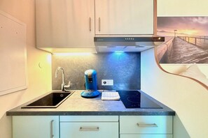 A modern kitchen with a built-in stove, a coffee maker, and a sink. - Holiday apartment with 1 bedroom (Kressbronn am Bodensee)