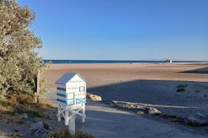 Een strand met een badwachtershutje met de tekst 'les plages' en 'Le cabanon' op een zandstrand.