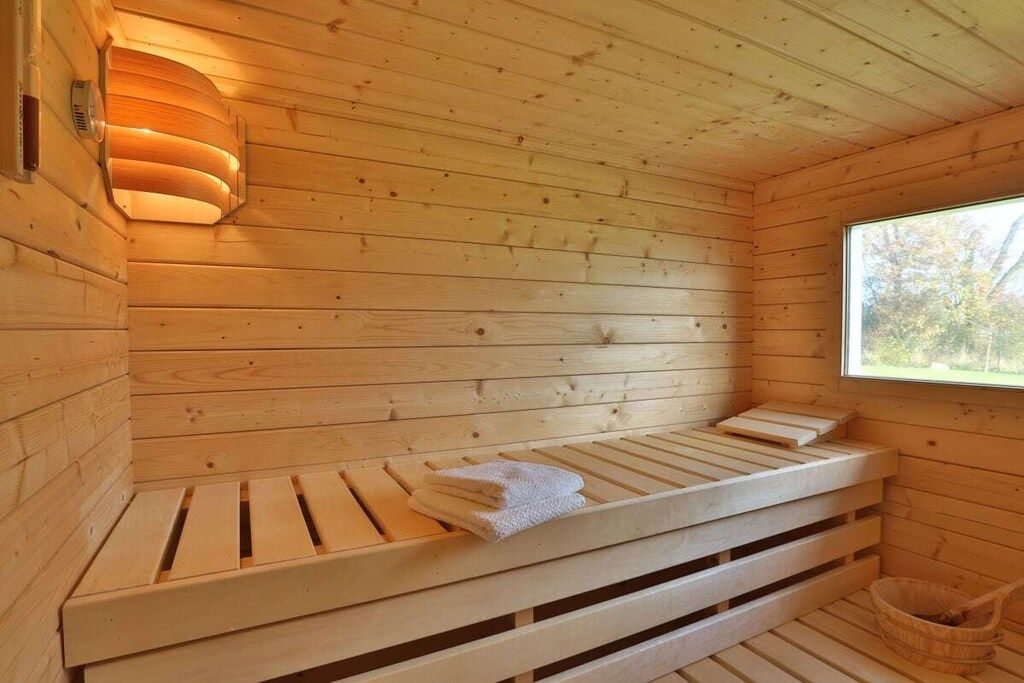 Eine Holzsauna mit Bänken, einem Handtuch und einem Fenster.