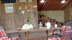 A rustic wooden interior with a table set for two, surrounded by plaid chairs. - Holiday apartment with 3 bedrooms (Marsberg)
