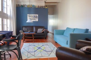 A living room with a sofa, a dining table, and chairs. - Holiday apartment in Tangermünde with Wi-Fi (Tangermünde)