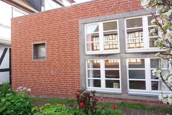 Een gebouw van rode baksteen met een raam en een klein vierkant raampje.