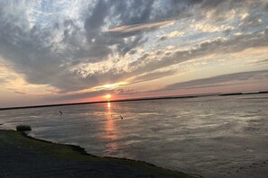 A sunset over a calm body of water with a clear horizon. - Holiday apartment with 1 bedroom (Dornumersiel)