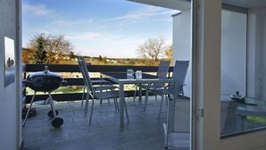 An outdoor patio with a grill, chairs, and a table. - Holiday home in Eifel with 4 bedrooms (Dockweiler)