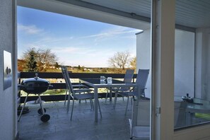 An outdoor patio with a grill, chairs, and a table. - Holiday home in Eifel with 4 bedrooms (Dockweiler)